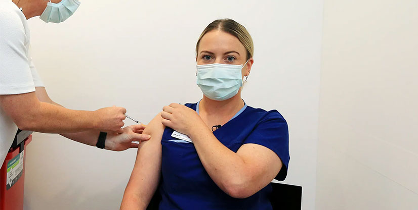 An Austin Health nurse receives her COVID-19 vaccination